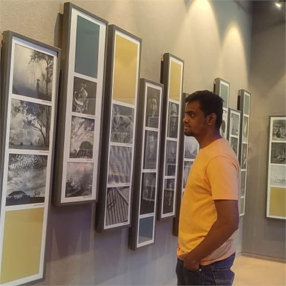 Sumeet looking at framed photography at an exhibition