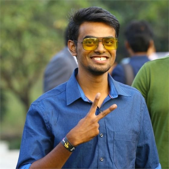 Sumeet smiling outdoors, giving a peace sign