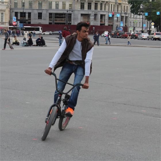 Sumeet riding a BMX bike across a public square in Saint Petersburg, Russia