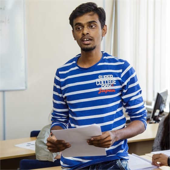Sumeet presenting to classmates in a classroom in Russia